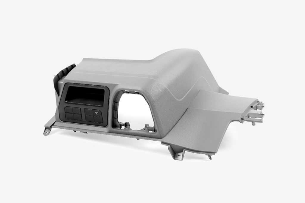 Car dashboard plastic component with textured surface and button slots